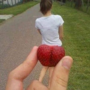 La nature est si belle... une fraise devant les fesses d'une jeune femme