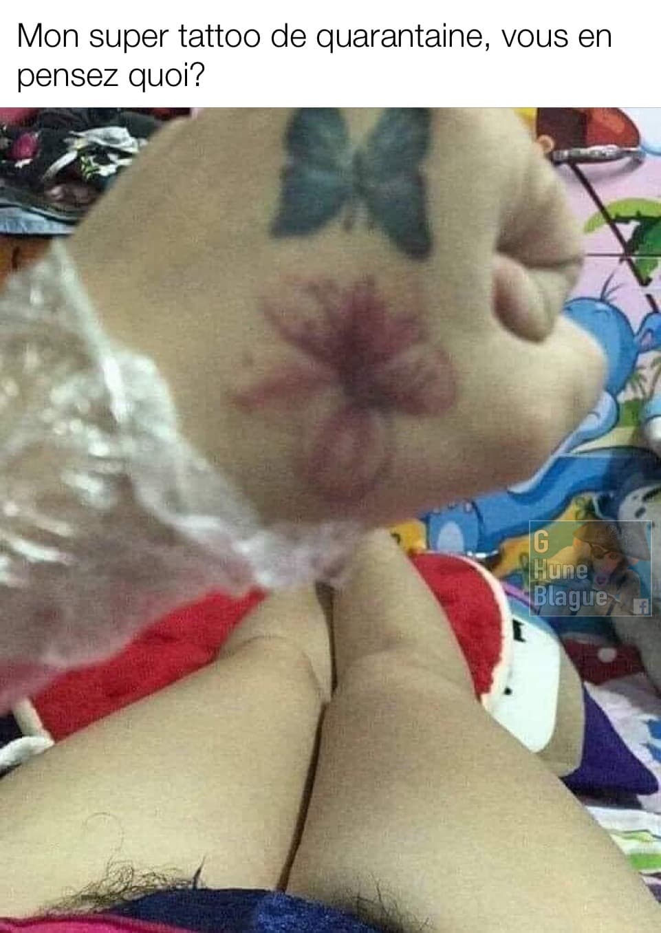 Un magnifique tattoo de papillon et de fleur... et en arrière plan du poils pubiens qui sort de sa culotte