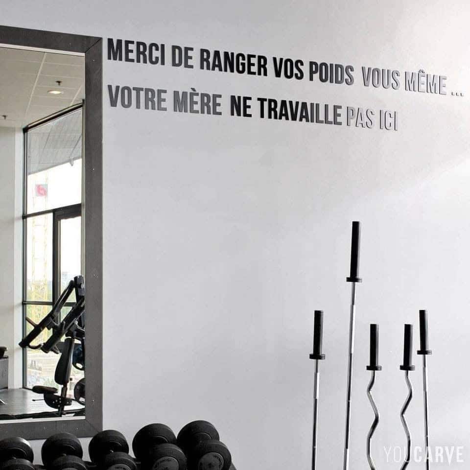 Écrit sur le mur du gym: Votre mère ne travaille pas au gym, rangez vos poids vous-même